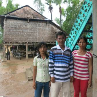 Theara and his two daughters in front of their house